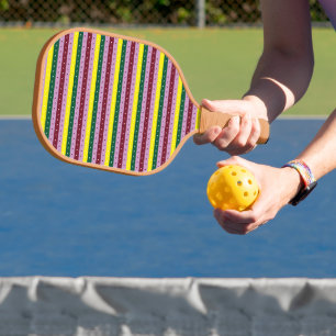 a multicolored striped background with dots pickleball paddle