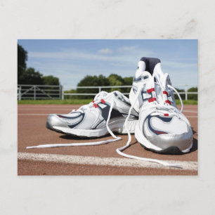 A pair of new white running trainers are placed postcard