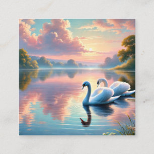 A pair of swans gliding on a serene lake square business card