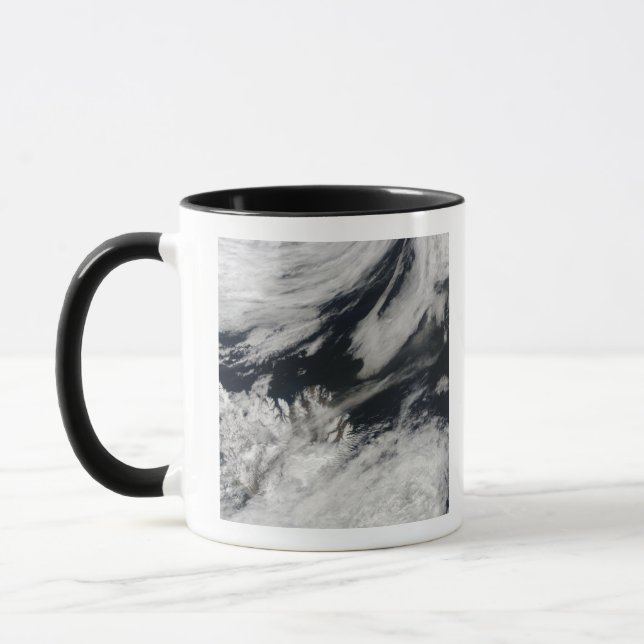 A pale grey ash plume blows from the summit mug (Left)