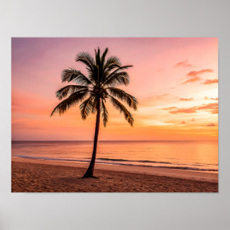 A palm tree stands alone on the beach at sunset poster