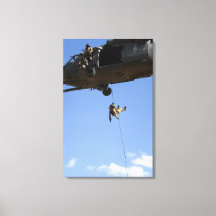 A pararescueman rappels from an HH-60 Canvas Print