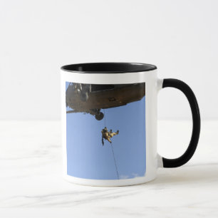 A pararescueman rappels from an HH-60 Mug