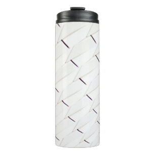 A pattern of white geometric shapes in a facade thermal tumbler