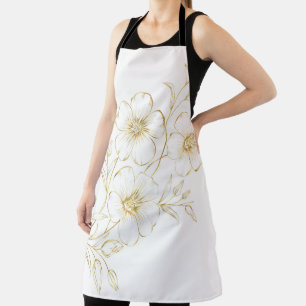 A person wearing a white apron with gold floral 