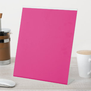 a pink background with a black border pedestal sign