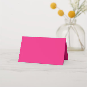 a pink background with a black place card