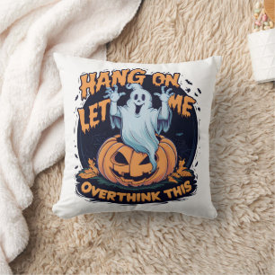 A playful ghost overthinking by a carved pumpkin cushion