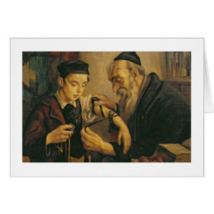 A Rabbi tying the Phylacteries to the arm of a boy