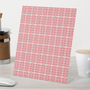a red and white background with small squares pedestal sign