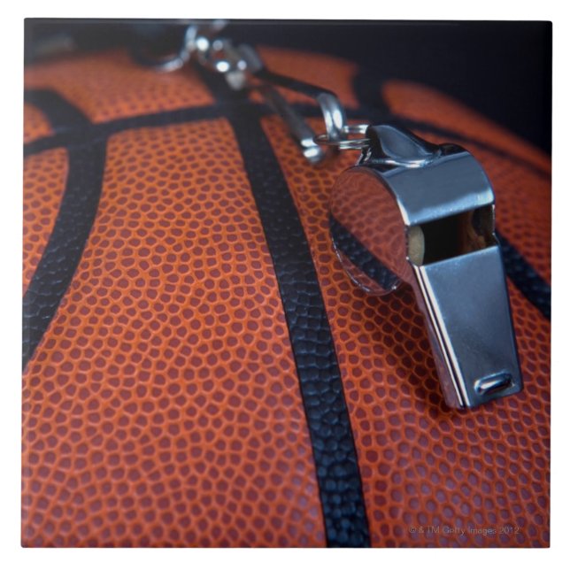 A referee's whistle rests on top of a tile (Front)