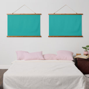 A rich teal green area highlighted by a contrastin hanging tapestry