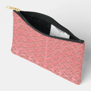 A rug with a red and pink motif features a decorat accessory pouch