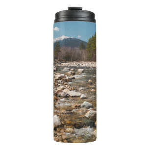 A running stream river with clear water flowing wi thermal tumbler
