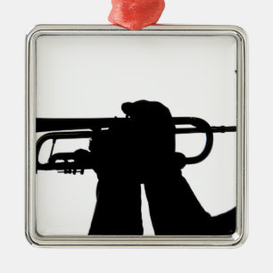 A service member plays a tune metal tree decoration