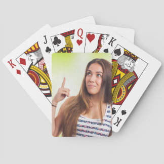 A smiling woman with long brown hair raises playing cards
