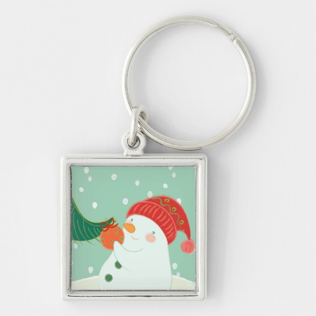 A snowman hanging an ornament on a tree key ring (Front)