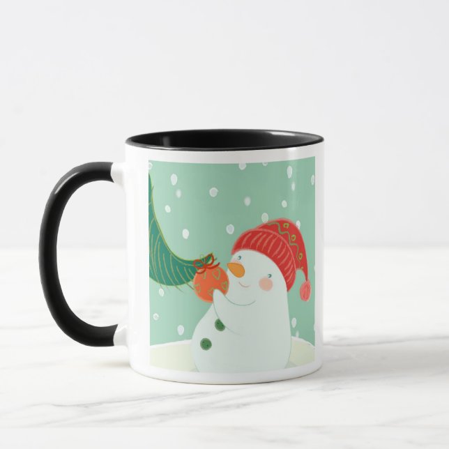A snowman hanging an ornament on a tree mug (Left)