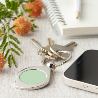 A soft pale green background fills the image key ring