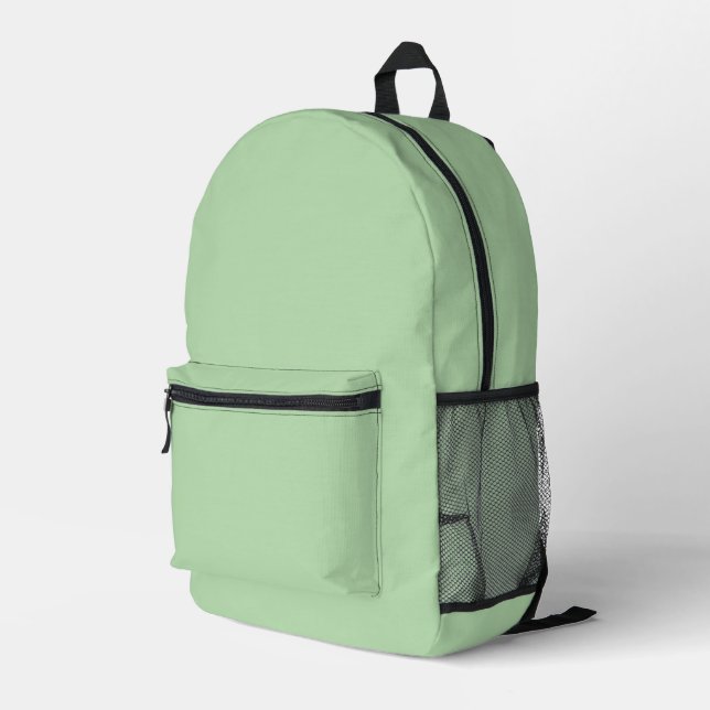 A soft pale green background fills the image printed backpack (Back Corner Right)