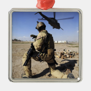 A soldier conducts security for an HH-60 Metal Tree Decoration