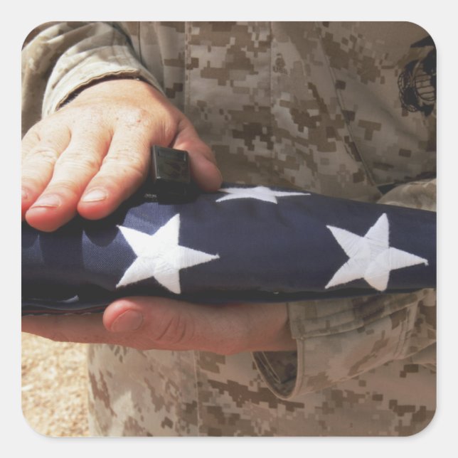 A soldier holds the United States flag Square Sticker (Front)