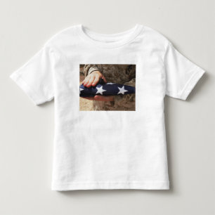 A soldier holds the United States flag Toddler T-Shirt