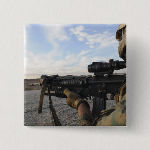 A soldier sights in to fire on a target 15 cm square badge