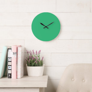 A solid green square positioned on a white backdro large clock