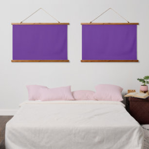 A solid purple background with a white square cent hanging tapestry