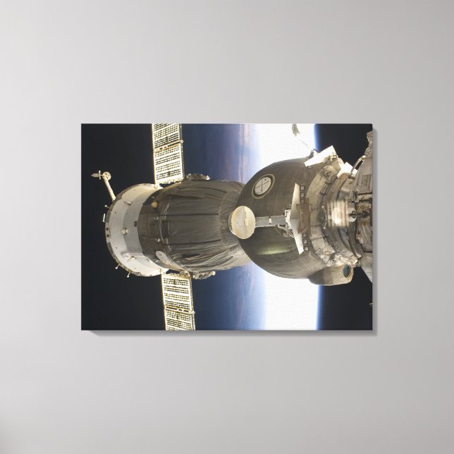 A Soyuz spacecraft backdropped by Earth Canvas Print (Front)