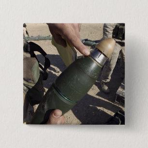 A squad leader points to a delay setting 15 cm square badge