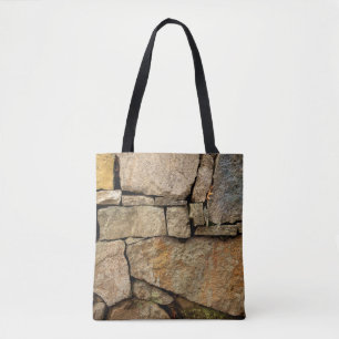 A stone wall made of cobblestones background textu tote bag