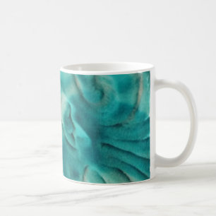 A swirling pattern in teal and light beige coffee mug