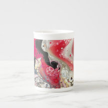 A tea or coffee mug with pink, gold, and black art