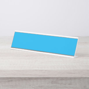 A vibrant blue sky with a few scattered white clou desk name plate