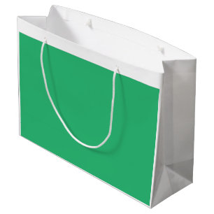 A vibrant green leaf with prominent veins and a de large gift bag