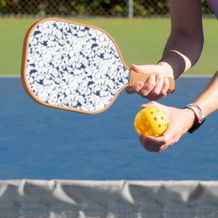 a white and blue background with a pattern pickleball paddle