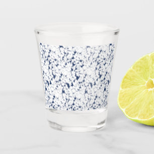 a white and blue background with a pattern shot glass