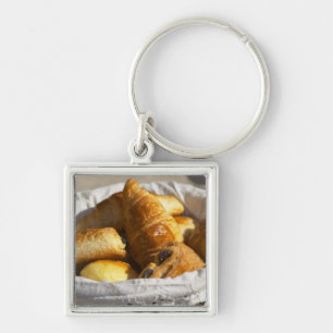 A wicker breakfast basket with croissants, and key ring