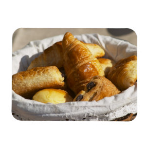 A wicker breakfast basket with croissants, and magnet