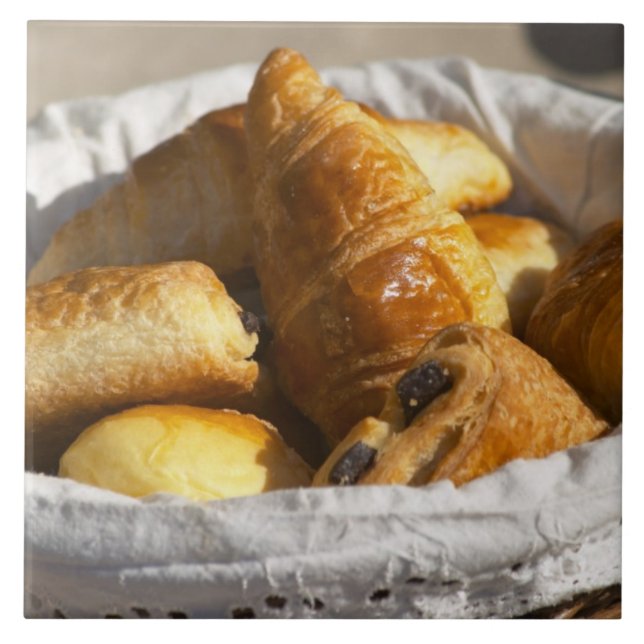 A wicker breakfast basket with croissants, and tile (Front)