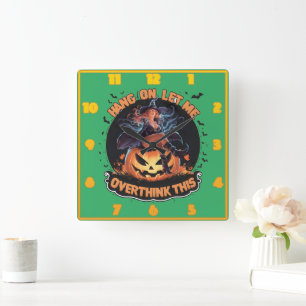 A witch playfully pondering atop a pumpkin square wall clock