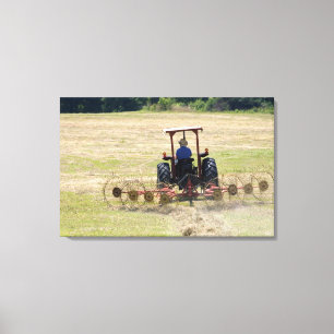 A young boy driving a tractor harvesting canvas print