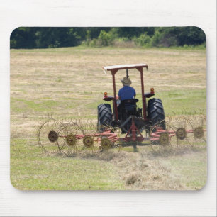 A young boy driving a tractor harvesting mouse mat