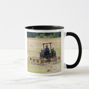 A young boy driving a tractor harvesting mug