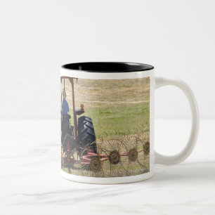 A young boy driving a tractor harvesting Two-Tone coffee mug