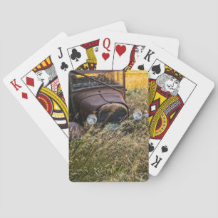 Abandoned old car in tall grass playing cards