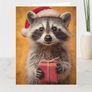 Adorable Raccoon in a Santa Hat Holding a Present Card