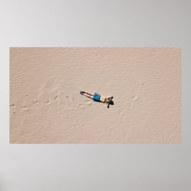 Aerial photograph of man lying on sand poster (Front)